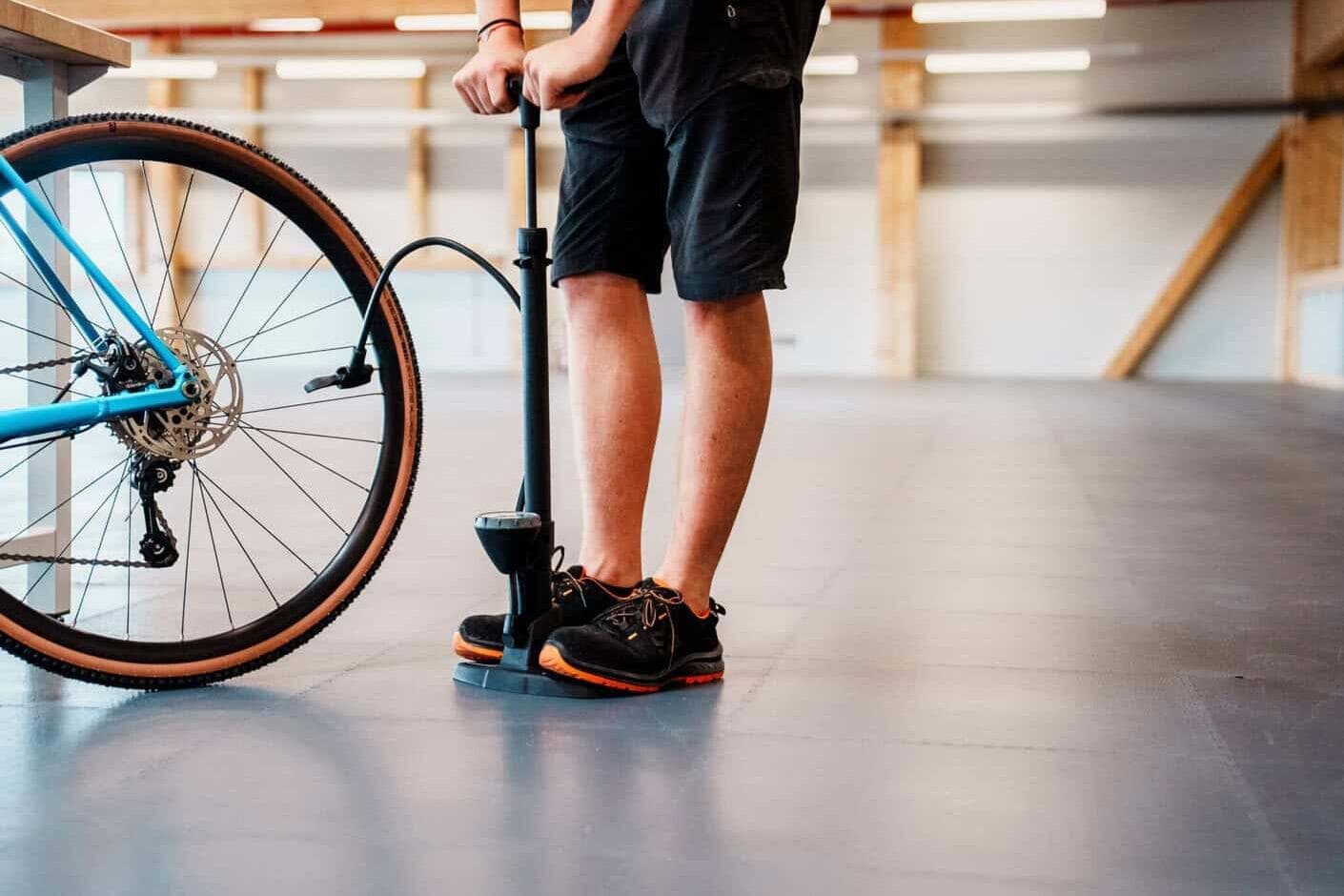 Ein Reifen wird mit der Standpumpe aufgepumpt