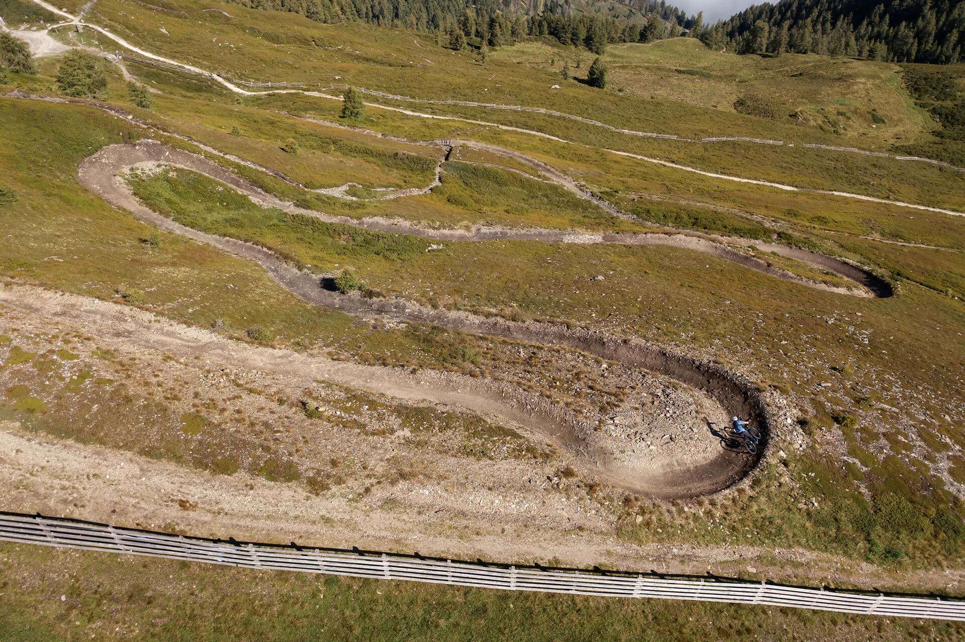 Luftbild eines Trails mit mehreren Kehren übereinander